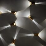 Modern wall sconces casting light patterns on wall