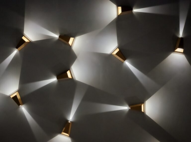 Modern wall sconces casting light patterns on wall