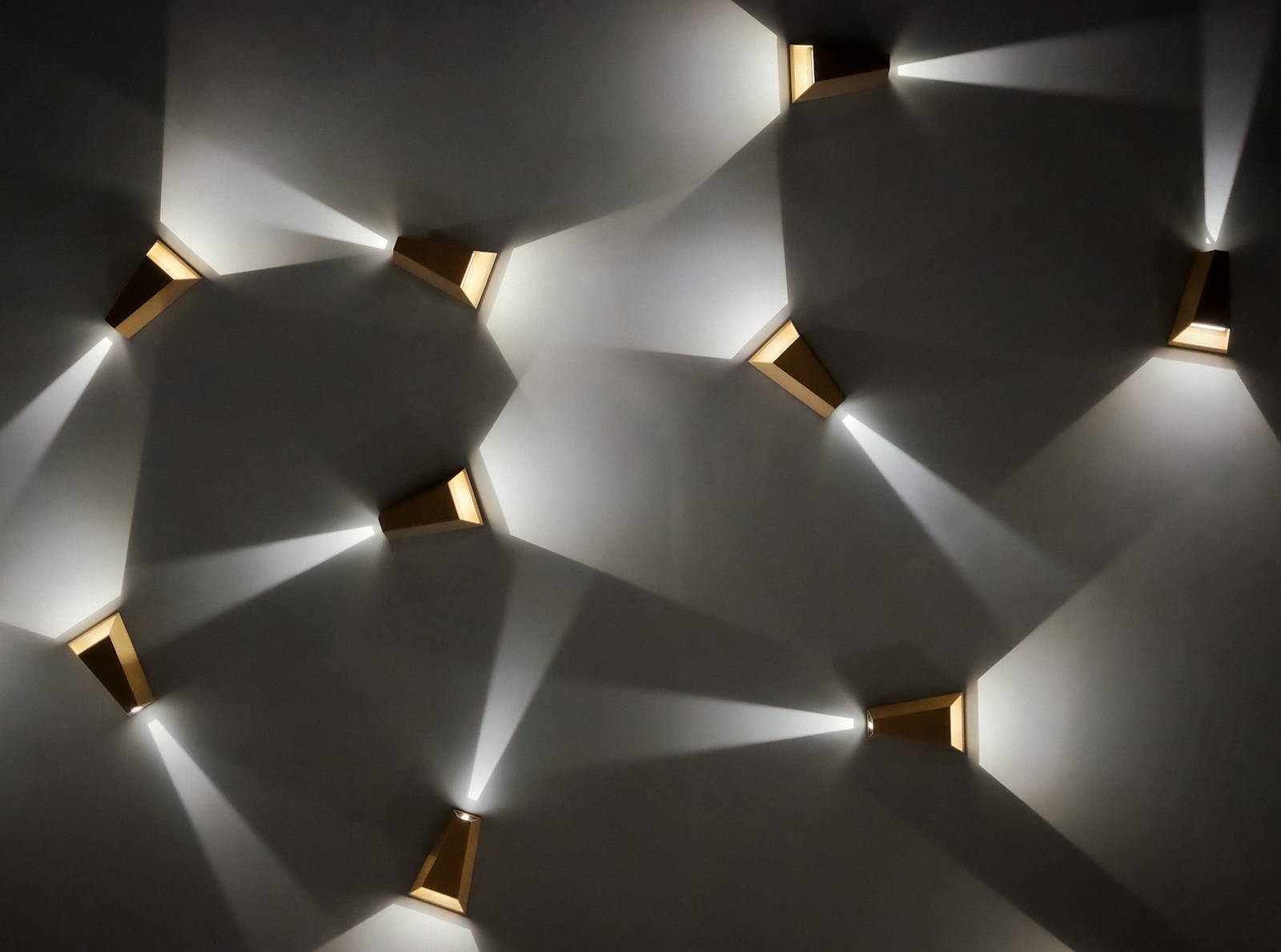 Modern wall sconces casting light patterns on wall